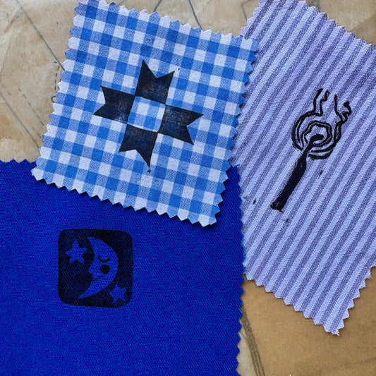 Four fabric swatches with different patterns on a textured surface