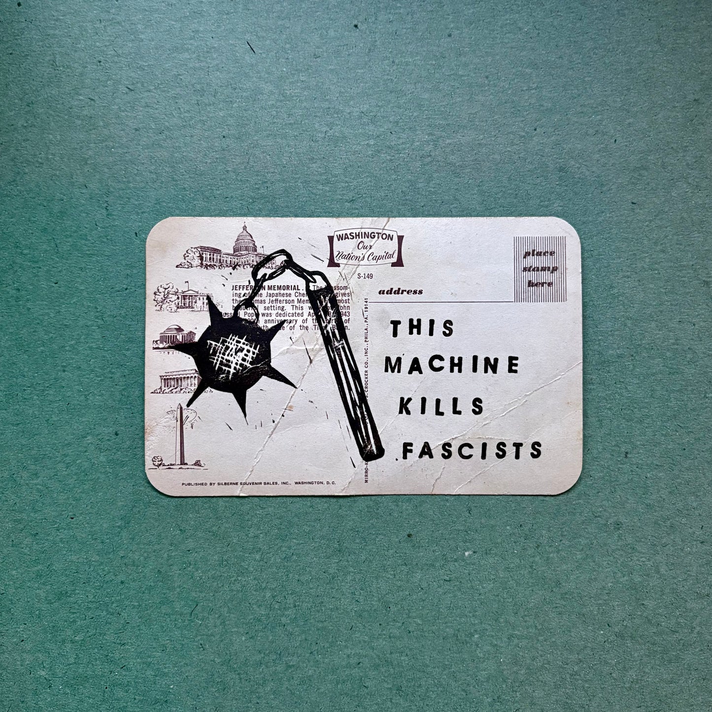 Sticker with a graphic and text 'This Machine Kills Fascists' on a textured green background