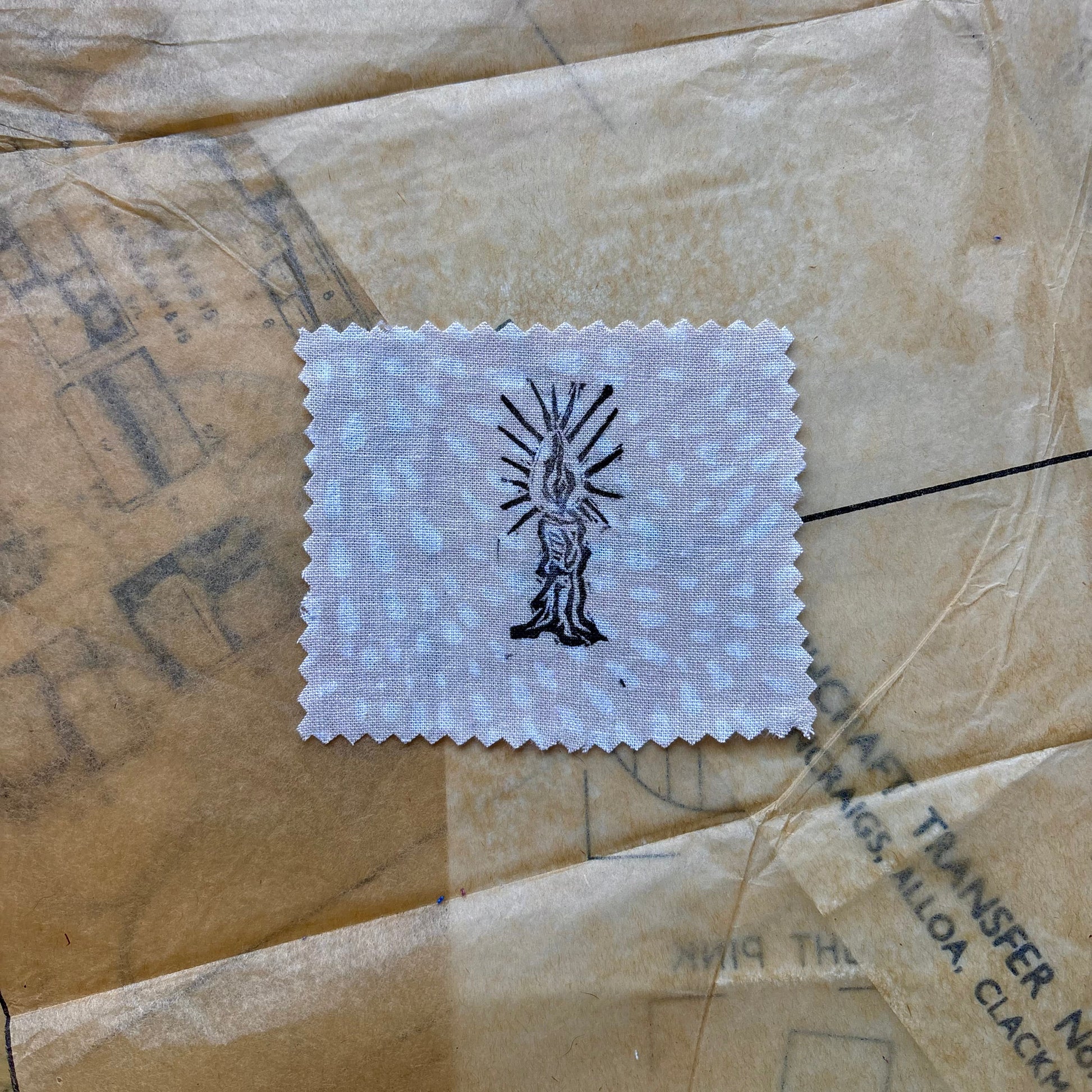 White patch with black design on a textured brown surface
