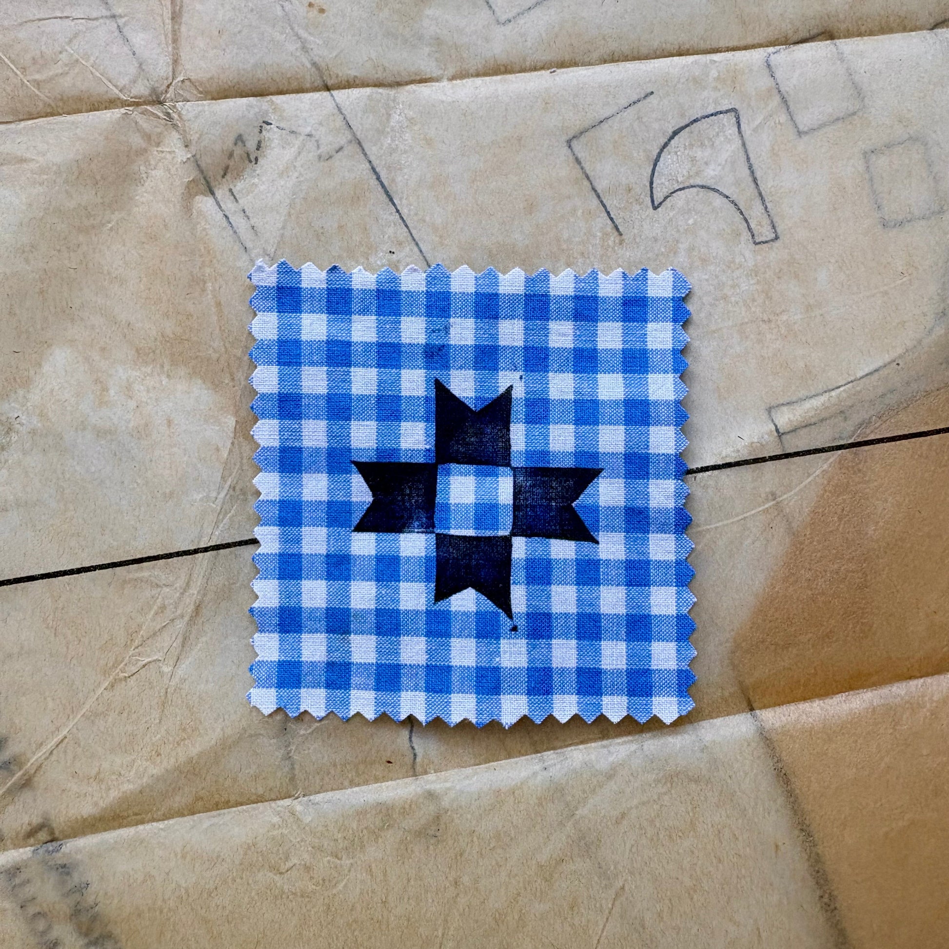 Blue and white checkered square with a black star on a textured beige background