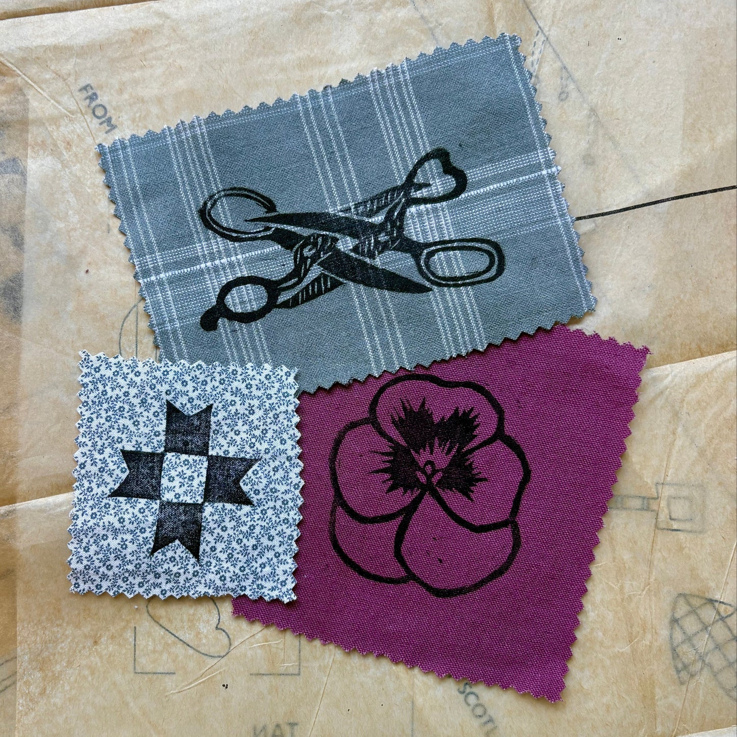 Three fabric swatches with designs on a textured surface