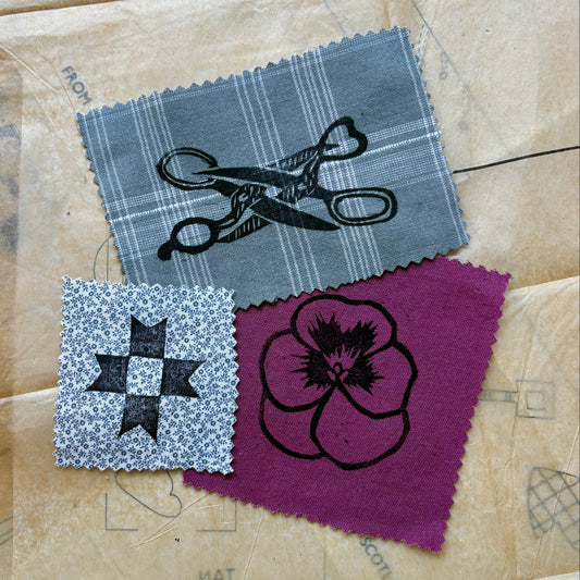Three fabric swatches with designs on a textured surface