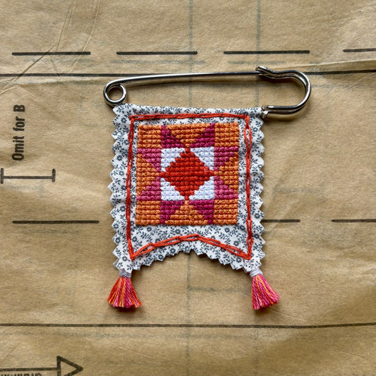 Embroidered keychain with geometric pattern on a wooden surface