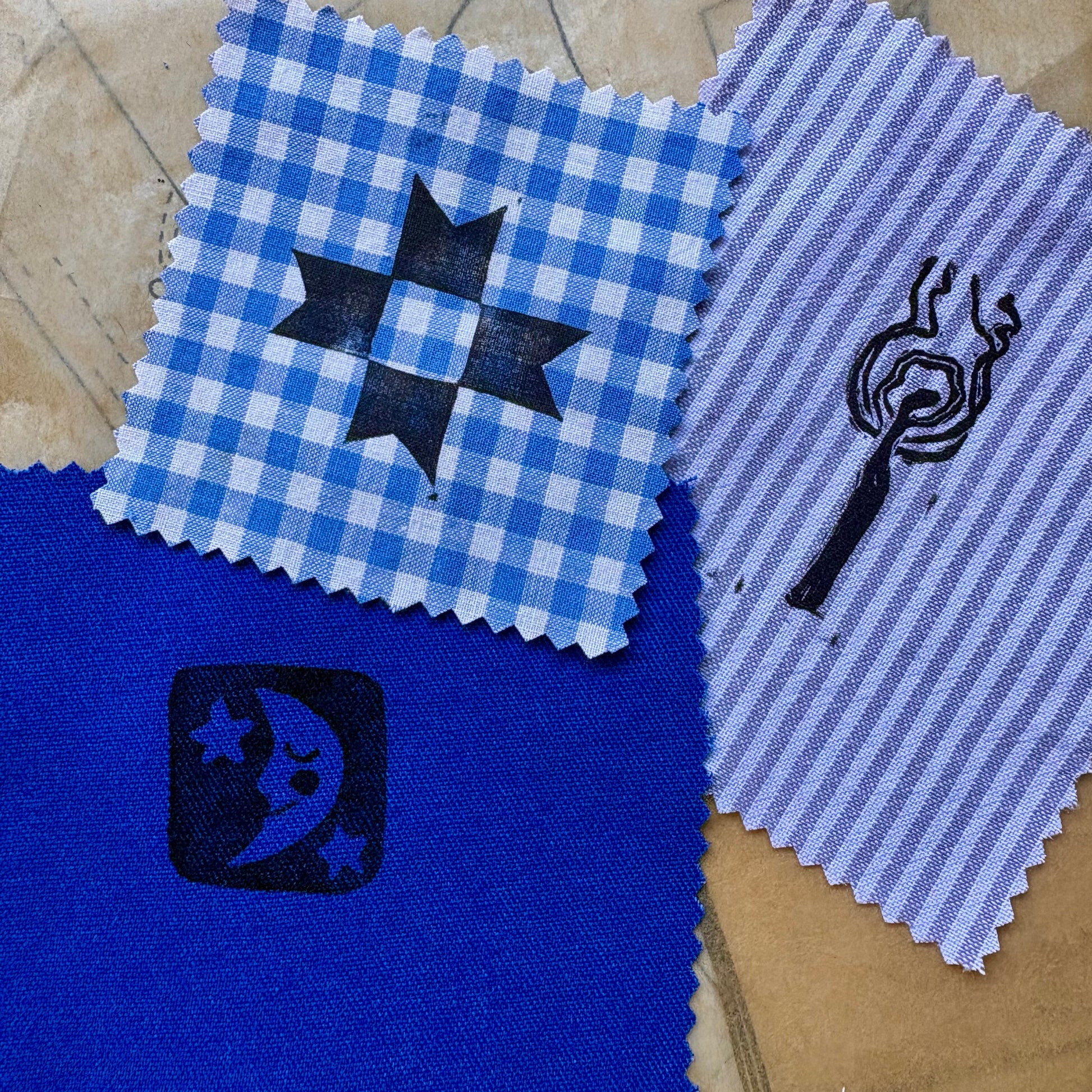 Four fabric swatches with different patterns on a textured surface