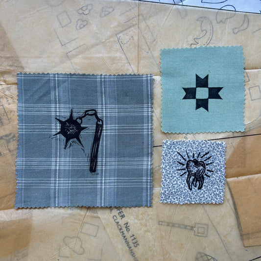 Fabric swatches with embroidered designs on a patterned paper background