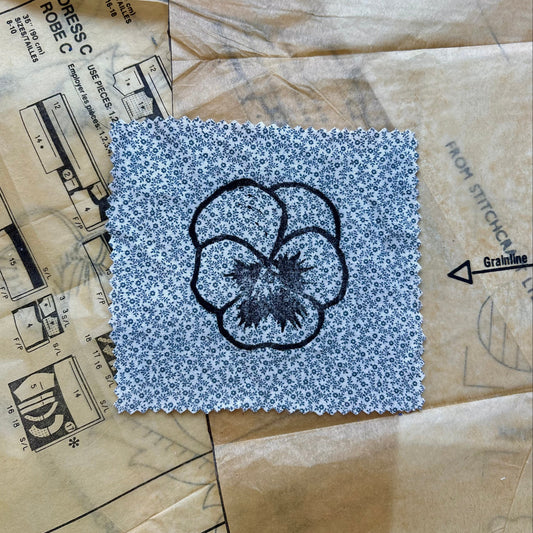 Square of fabric with a floral design on a textured surface
