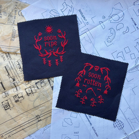 Two black patches with red text and graphics on a paper background