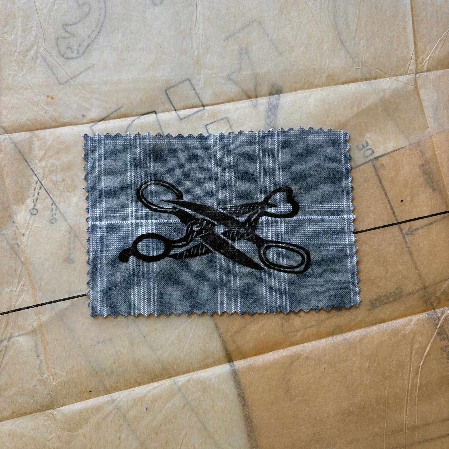 Fabric swatch with scissors design on a textured surface