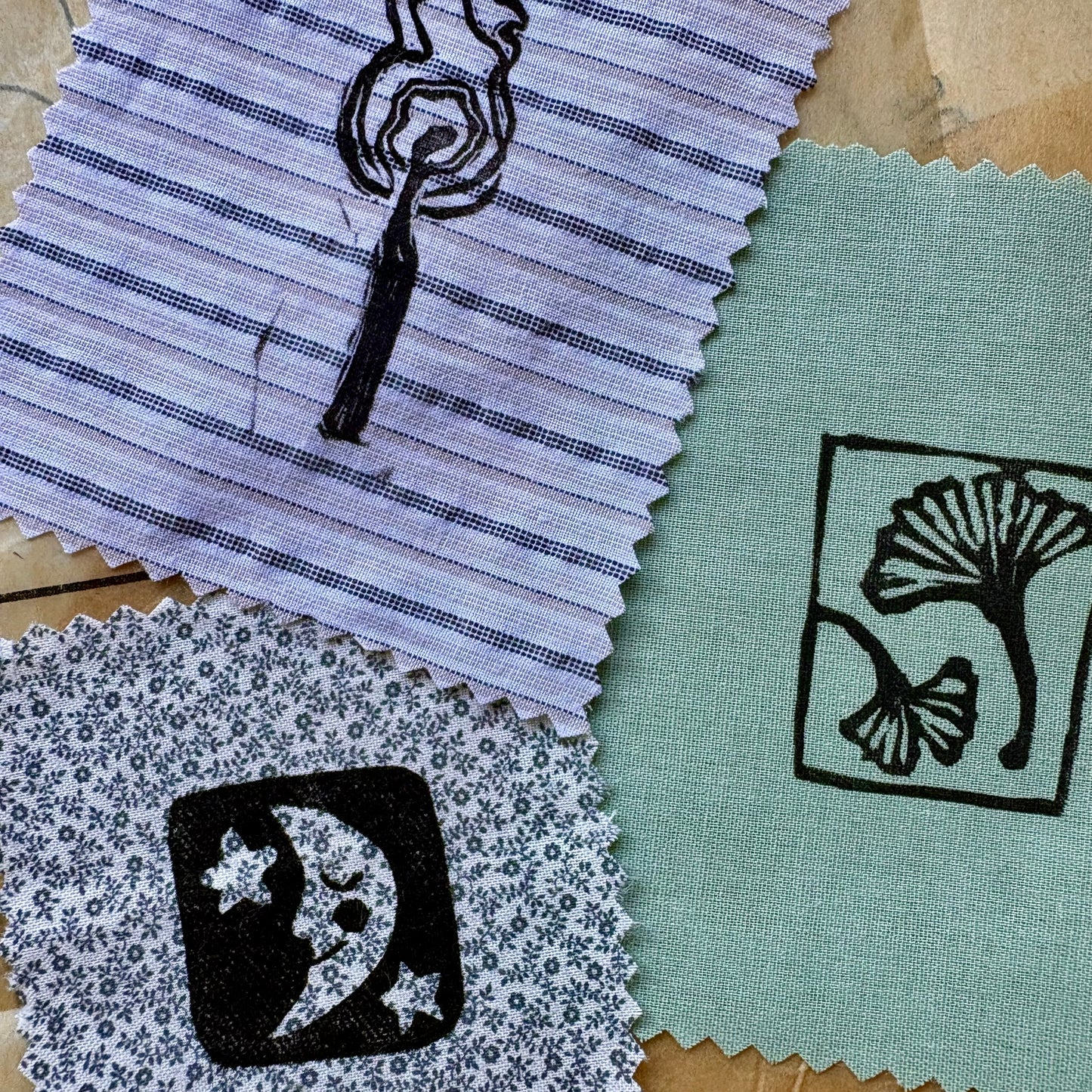 Fabric swatches with printed designs on a textured surface